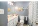 A bathroom features a vanity sink, toilet and shower with blue patterned shower curtain at 6355 Queens Rd, Douglasville, GA 30135