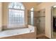 Bathroom featuring soaking tub with jets and a glass enclosed shower at 755 Creek Wind Ct, Johns Creek, GA 30097