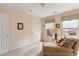 Bright bedroom with a cozy chaise lounge, large windows, and neutral tones, creating a relaxing space at 755 Creek Wind Ct, Johns Creek, GA 30097