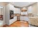 Bright kitchen features white cabinets, granite countertops, stainless steel appliances, and hardwood flooring at 755 Creek Wind Ct, Johns Creek, GA 30097