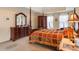 Bright main bedroom featuring a tray ceiling, a four-poster bed, and a wooden dresser at 755 Creek Wind Ct, Johns Creek, GA 30097