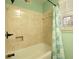 Traditional bathroom with a shower-tub combo, neutral tile, and shuttered window at 1728 Stonecliff Ct, Decatur, GA 30033