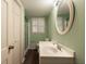 Functional bathroom with light green walls, white vanity, a shower and a shuttered window at 1728 Stonecliff Ct, Decatur, GA 30033