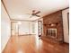 Open living room featuring a brick fireplace, hardwood floors, and ample natural light at 1728 Stonecliff Ct, Decatur, GA 30033