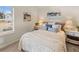 Well-lit bedroom with light colored walls, patterned bedding, and views out the window at 2198 Cormac St, East Point, GA 30344