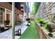 Backyard featuring a covered patio with outdoor seating, artificial turf, and a stone retaining wall with lush greenery at 3280 Stillhouse Se Ln # 108, Atlanta, GA 30339