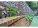 Close up of a stone retaining wall with vibrant flowers and greenery in the landscaped backyard at 3280 Stillhouse Se Ln # 108, Atlanta, GA 30339