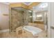 Bathroom featuring walk-in glass shower, soaking tub, and marble tile at 3280 Stillhouse Se Ln # 108, Atlanta, GA 30339