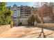 Wide exterior shot of a condo building surrounded by lush greenery and mature trees at 3280 Stillhouse Se Ln # 108, Atlanta, GA 30339