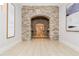 Hallway with stone archway leading to tiled floors, flanked by artwork and decorative lighting at 3280 Stillhouse Se Ln # 108, Atlanta, GA 30339