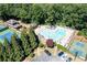 Aerial view showcasing the pool with lounge chairs and tennis courts, nestled among mature trees at 4481 Windsor Oaks Dr, Marietta, GA 30066