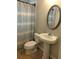 This bathroom features a vanity with a pedestal sink and an oval mirror and a toilet at 818 Burchill Sw St, Atlanta, GA 30310