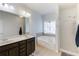 Elegant bathroom featuring a soaking tub, double sinks, dark wood cabinets, and a glass door shower at 108 Trailside Cir, Hiram, GA 30141