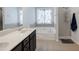 Stylish bathroom featuring a tub beneath a window, neutral-toned tile floors, and glass door shower at 108 Trailside Cir, Hiram, GA 30141