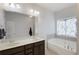 Elegant bathroom featuring a soaking tub, double sinks, dark wood cabinets, and a glass door shower at 108 Trailside Cir, Hiram, GA 30141