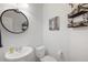 Cozy powder room with a pedestal sink, decorative mirror, and shelving for added charm at 108 Trailside Cir, Hiram, GA 30141