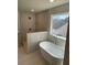 Modern bathroom featuring a soaking tub and tiled walk-in shower, and large window at 1335 Tumblerock Way, Loganville, GA 30052