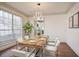 Bright dining room features hardwood floors, table set and large windows, connecting to the kitchen at 275 Carriage Chase, Fayetteville, GA 30214