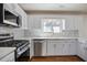 Modern kitchen with stainless steel appliances, white cabinets, and marble backsplash at 275 Carriage Chase, Fayetteville, GA 30214