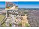 Aerial view showcases a home with a pristine lawn, nearby golf course, and surrounding lush greenery in a serene neighborhood at 49 Inverness Ct, Hiram, GA 30141