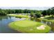 Scenic aerial view of a lush golf course with a pond and clubhouse, perfect for luxury living at 49 Inverness Ct, Hiram, GA 30141