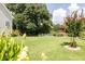 Large backyard with a wooden deck, wooden fence, and landscaped garden beds at 49 Inverness Ct, Hiram, GA 30141