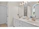 Bathroom featuring double sink vanity, white cabinets, marble countertops, and elegant lighting fixtures at 49 Inverness Ct, Hiram, GA 30141