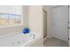 Modern bathroom with soaking tub with window view, shower and white door at 49 Inverness Ct, Hiram, GA 30141