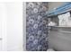 Stylish bathroom with patterned wallpaper and organized shelving at 49 Inverness Ct, Hiram, GA 30141