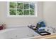 Large white soaking tub with caddy and window view at 49 Inverness Ct, Hiram, GA 30141