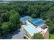 Overhead shot of a community pool and tennis courts surrounded by lush green trees and ample parking at 49 Inverness Ct, Hiram, GA 30141