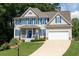 Charming two-story home with blue shutters, white trim, inviting porch, and well-manicured lawn at 49 Inverness Ct, Hiram, GA 30141