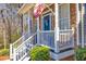 Inviting front porch with stone accents, white railings, and a vibrant blue door at 49 Inverness Ct, Hiram, GA 30141