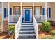 Welcoming front porch with white railings, stone accents, and a bright blue front door at 49 Inverness Ct, Hiram, GA 30141