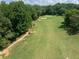 Aerial view of lush golf course and green surrounded by dense trees at 49 Inverness Ct, Hiram, GA 30141