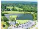 Aerial image of golf course with a pond and green, close to community clubhouse with ample parking at 49 Inverness Ct, Hiram, GA 30141