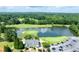 Golf course aerial featuring a serene pond, lush green fairways, mature trees, and community clubhouse at 49 Inverness Ct, Hiram, GA 30141