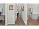 Inviting hallway with wood floors, neutral walls, decorative art, and views into adjacent rooms at 49 Inverness Ct, Hiram, GA 30141
