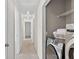 Hallway leading to laundry closet with modern washer and dryer, wire rack shelving at 49 Inverness Ct, Hiram, GA 30141
