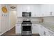 Kitchen featuring stainless steel oven/range, microwave, granite countertops, and a decorative tile backsplash at 49 Inverness Ct, Hiram, GA 30141