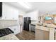 Modern kitchen featuring stainless steel appliances, granite countertops, and an open layout to the living area at 49 Inverness Ct, Hiram, GA 30141