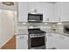 Modern kitchen featuring white cabinets, granite countertops, stainless steel appliances, and ample lighting at 49 Inverness Ct, Hiram, GA 30141