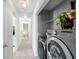 Hallway view of laundry area with modern front-load washer and dryer in grey at 49 Inverness Ct, Hiram, GA 30141