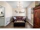Cozy living room featuring a leather sofa, a decorative chandelier, and a view into the kitchen at 49 Inverness Ct, Hiram, GA 30141