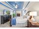Main bedroom featuring a blue tray ceiling, TV on media center, and natural light from window at 49 Inverness Ct, Hiram, GA 30141