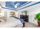 Main bedroom with a blue tray ceiling, entertainment center, and natural lighting at 49 Inverness Ct, Hiram, GA 30141