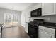 Well-equipped kitchen with black appliances, light gray cabinets, and a breakfast nook at 6005 Pattingham Dr, Roswell, GA 30075