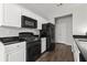 Well-lit kitchen features white cabinets, black appliances, and dark countertops at 6005 Pattingham Dr, Roswell, GA 30075