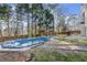 Backyard featuring an in-ground pool with safety cover, patio, and wooded area at 6005 Pattingham Dr, Roswell, GA 30075