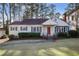 Charming home with a red front door, complemented by lush landscaping and a well-manicured lawn at 1258 Merry Ne Ln, Atlanta, GA 30329